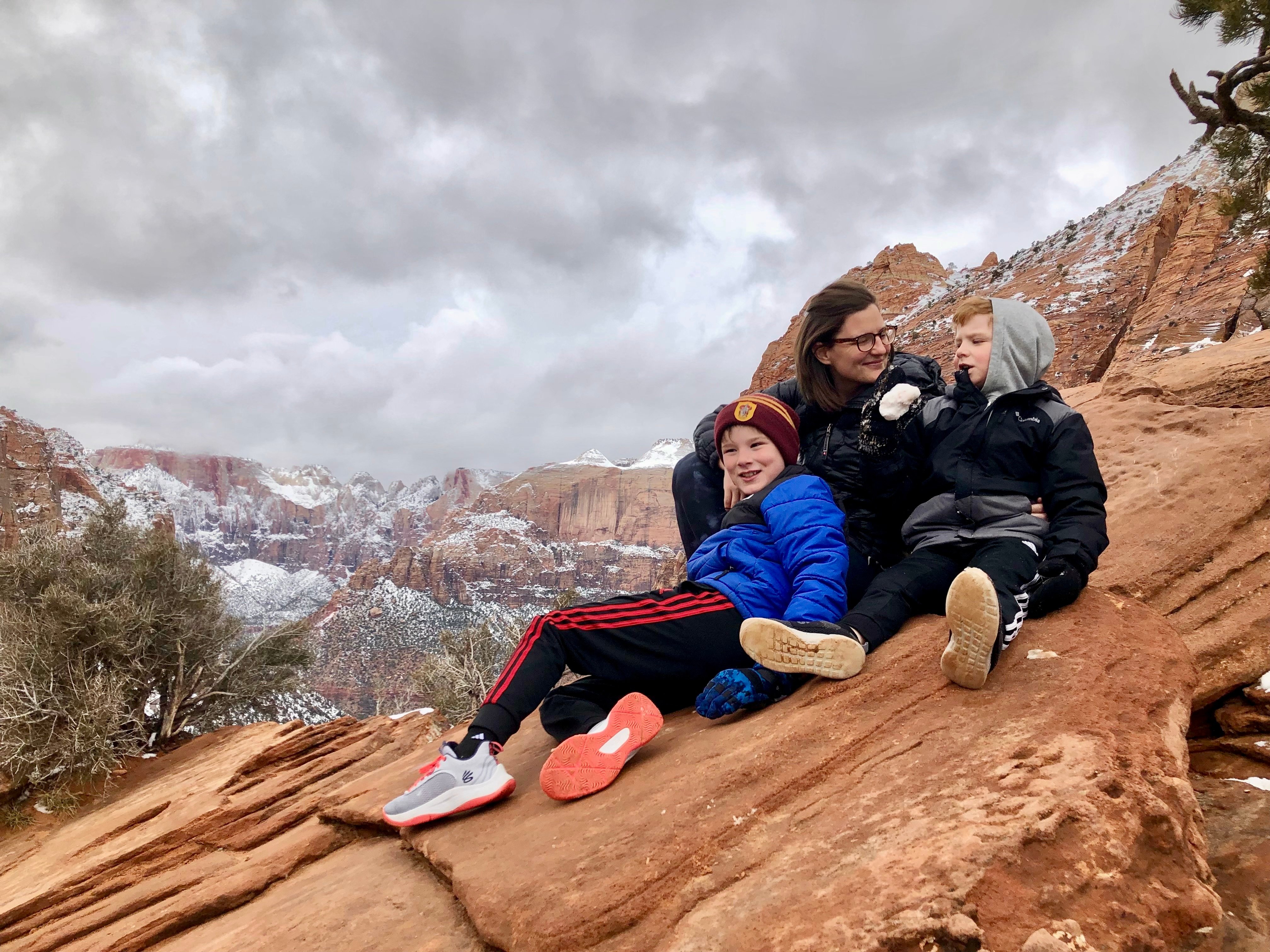 Theresa Murray sitting on a canyon with her two sons
